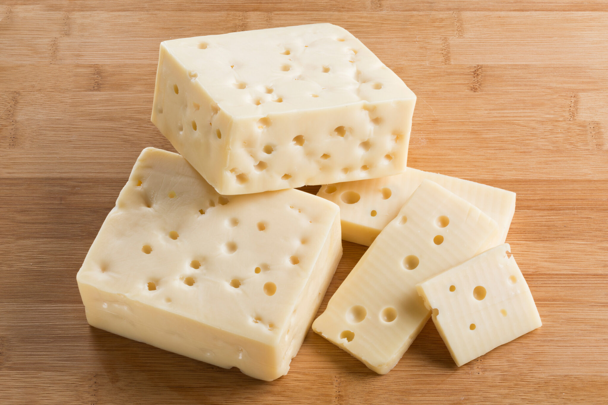 how are the holes in swiss cheese formed
