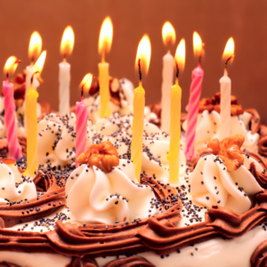 how did the tradition of putting candles on a birthday cake originate and what does the custom mean