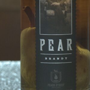 how do brandy distilleries get a whole pear into a bottle of pear brandy