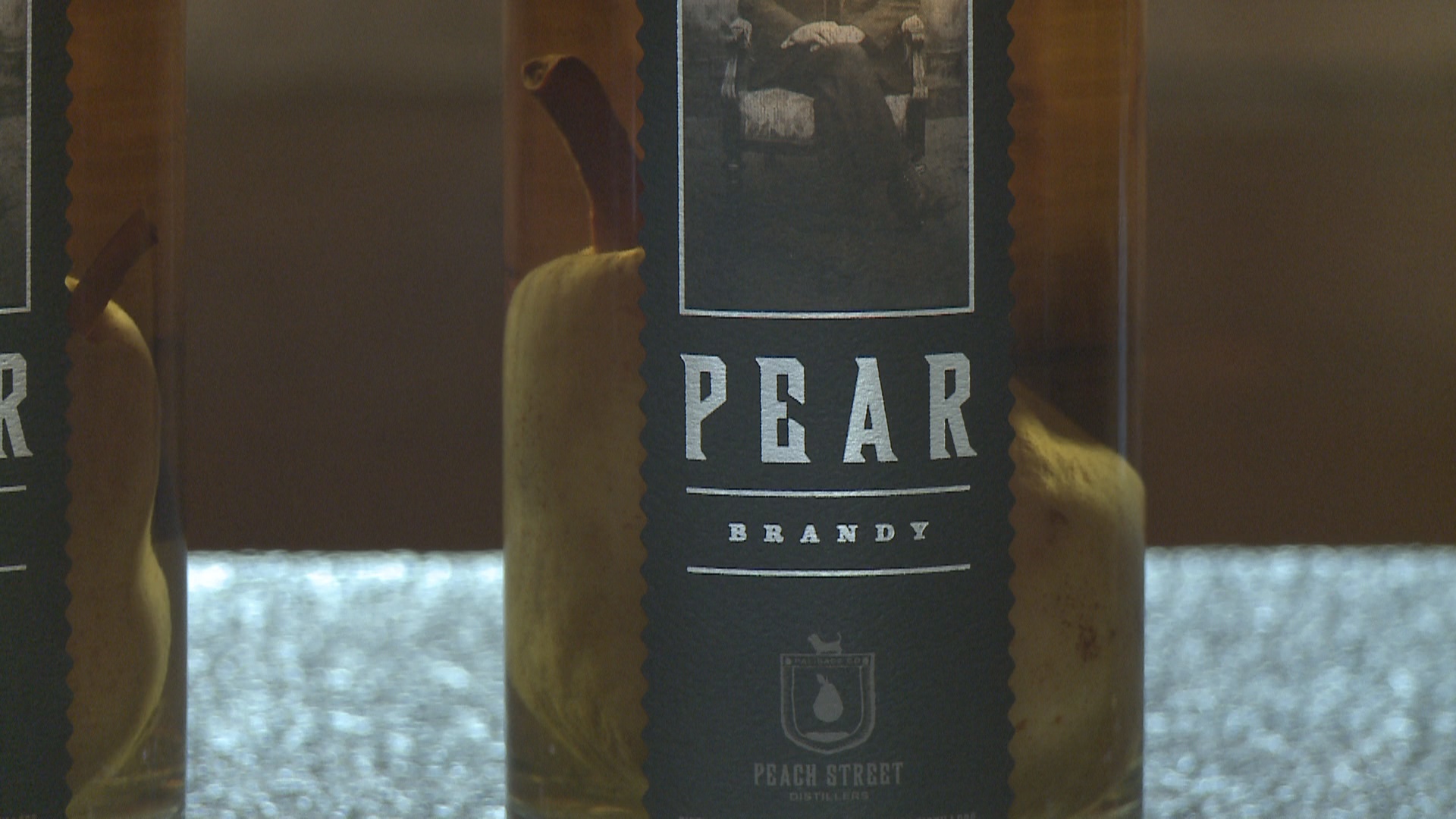 how do brandy distilleries get a whole pear into a bottle of pear brandy