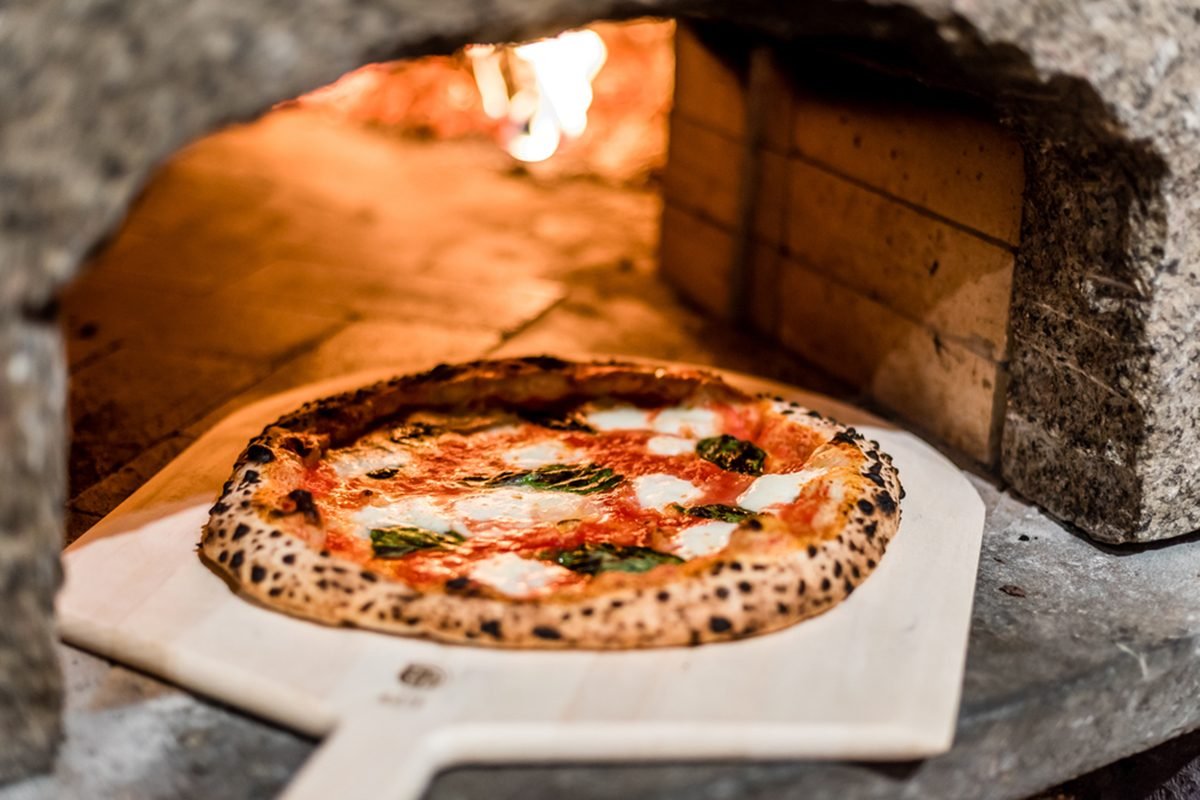 why does pizza taste better when baked in a brick oven or on a pizza stone