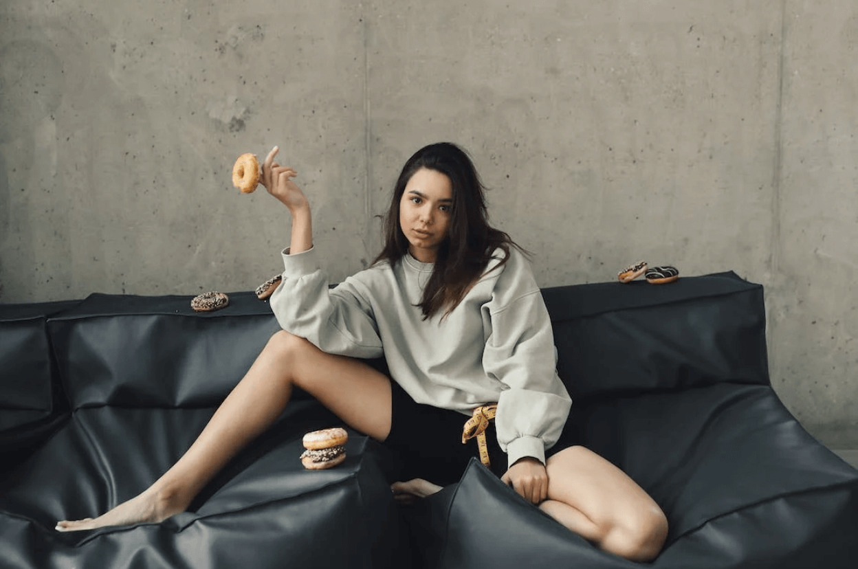woman sitting with a donut on her finger